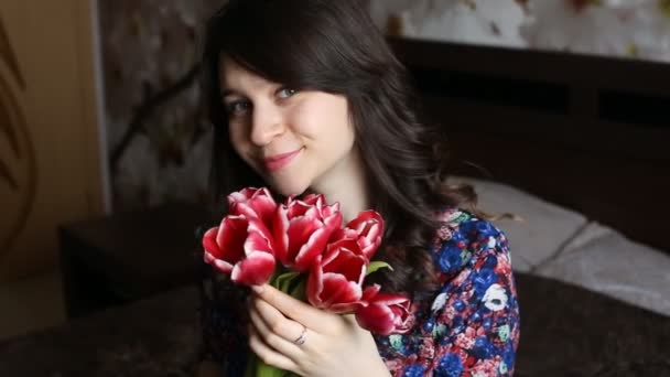 Beautiful girl holding flowers, looking at the camera, smiling, flirting.