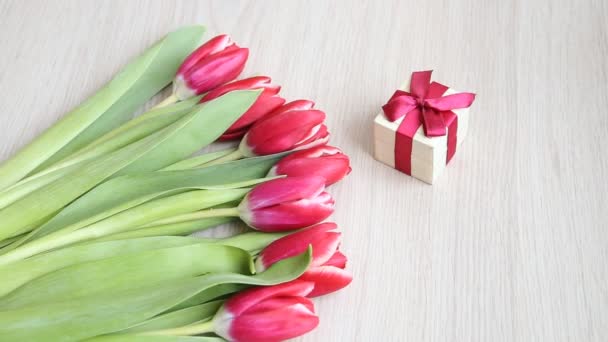 Déposez des fleurs à côté du présent. Fleurs se déplacent du cadre pour faire place à une inscription . — Video
