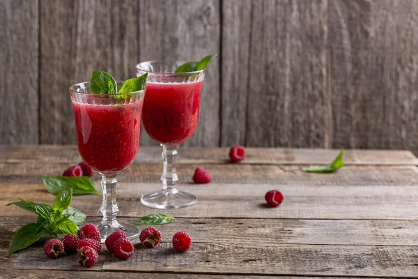 Raspberry drink-cocktail with Basil. Rustic style, wooden background, feed in the glass.