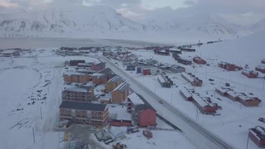 İHA uçuşu. Longyearbyen 'in havadan görünüşü, Svalbard' ın kışın. Dağlarla ve renkli evlerle manzara. Renk düzeltmesi olmadan D günlüğünde resim. Yüksek kalite 4k görüntü