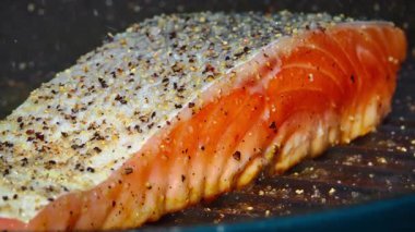 Dökme demir tavada pişen sulu somon bifteğinin yakın çekimi. Sağlıklı beslenme konsepti. Yüksek kalite 4k görüntü