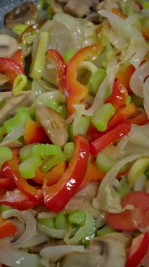 Sıcak tavaya atılmış karışık sebzeler, mantarlar, soğanlar, soğanlar, soğanlar ve biberler birleşimi, spatula çevirme hareketi, canlı karıştırma, cızırtılı aroma, renkli sağlıklı yemek, yavaş çekim video fps