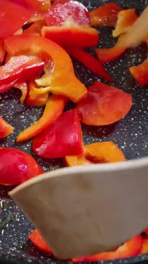 Canlı renkte biberlerle hararetli sebze karışımı, canlı sebze kızartması, canlı biberler, kaynayan yağda çabucak kızartılıyor ve yavaş çekim video fps baharatları ekleniyor.