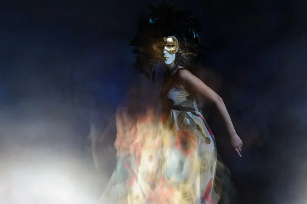 Girl in mask is dancing in light