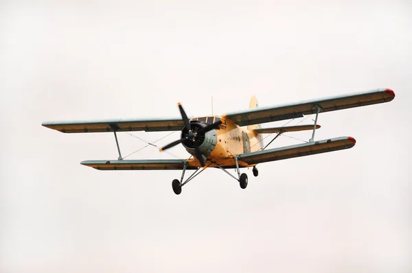 Old classic biplane flying in the air Stock Image