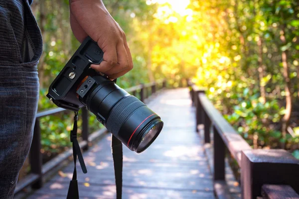Dslr fotoğraf makinesi tutan el resim kırpılmış. Fotoğrafçı kavramı