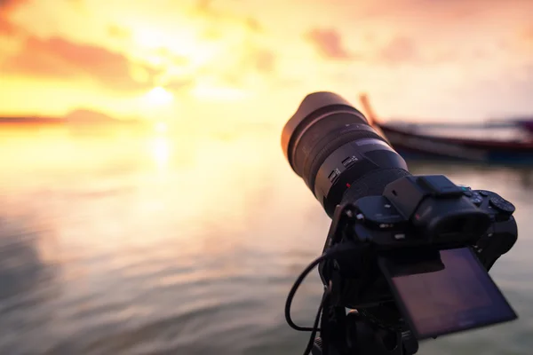 Profesyonel dijital fotoğraf makinesi odak gündoğumu manzaraya bir plaj.