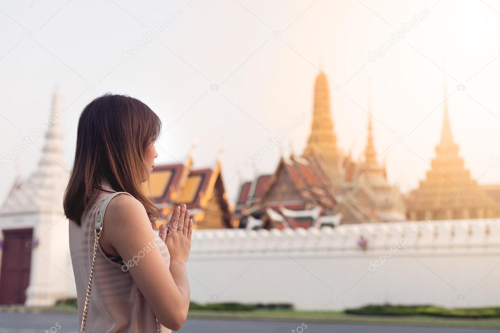 Thai woman praying at Emerald Buddha temple, Grand palace. concept about religion and landmarks