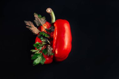 Siyah arka planda kırmızı, tatlı biber ve maydanoz.