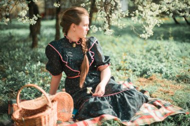 Güzel kız parkta yerde oturuyor.