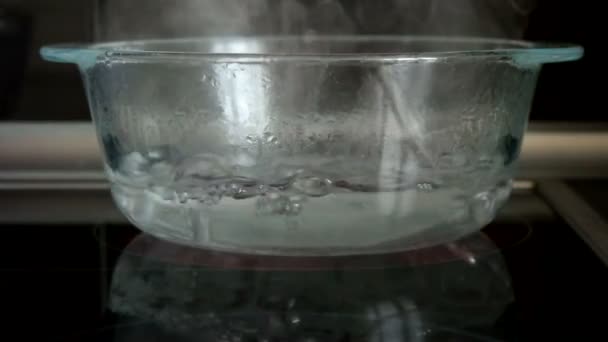 Wasser kocht in Glasschüssel — Stockvideo