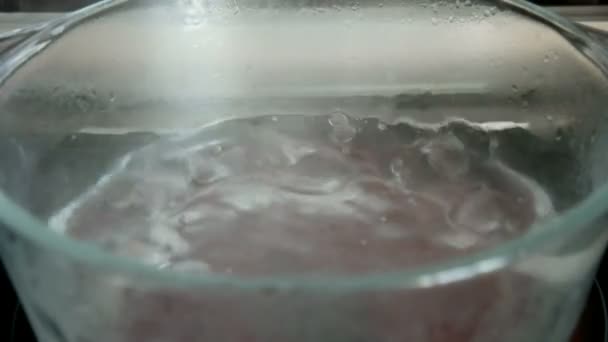 Wasser kocht in Glasschüssel — Stockvideo