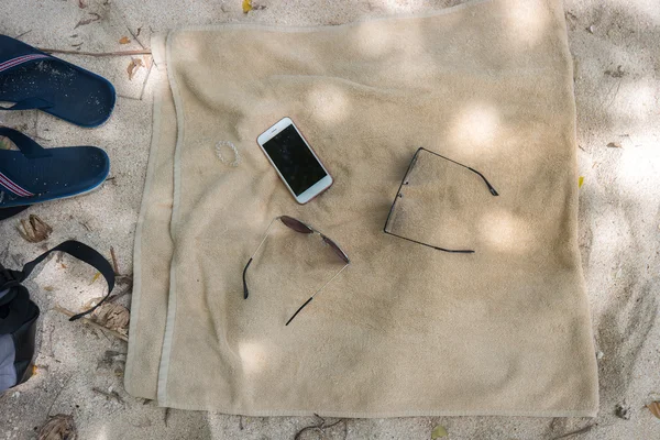 Flip flops, sunglasses, towel on the beach