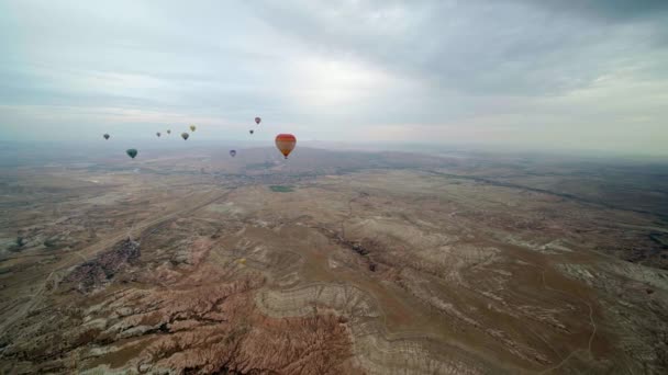 Heteluchtballonnen die over het berglandschap vliegen — Stockvideo