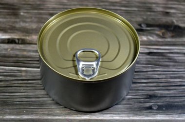 a metal tin can with a pull-tab lid, a common type of packaging for canned food, the cans used to preserve food, such as fish and provide a long shelf life, canned fish tuna, selective focus