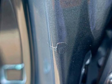 Araba boyasında bir çizik var. Temiz kaplama ve metali boyamadan geçmemiş. Daha derin bir hasar alan küçük bir alan.