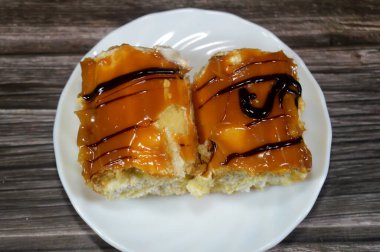 Krem şanti ile dolu sünger keki, karamel ve koyu çikolata yağmuru ile kaplı, vanilyalı sünger keki karamel ve krem şantili gateau ile