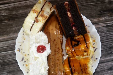 Çeşitli kapılar, çikolatalı pasta, beyaz orman pastası, bisküvi katmanlı ekler, beyaz çikolata katmanlı İsviçre dürümü ve krem şanti ile kaplanmış, üzeri karamel kaplı Sünger keki.