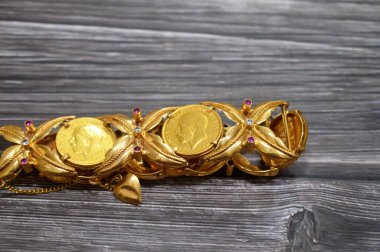 İçinde Kral V. George 'un altın sikkeleri bulunan bir bilezik, Kral V. George ve klasik Aziz George ve Ejderha, değerli metal mücevherler, altın fiyat, değerli bileklikler,