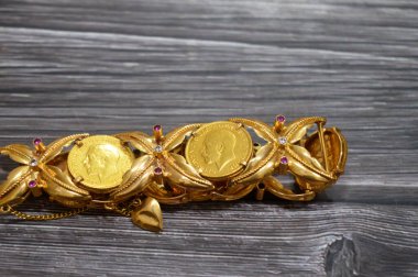 İçinde Kral V. George 'un altın sikkeleri bulunan bir bilezik, Kral V. George ve klasik Aziz George ve Ejderha, değerli metal mücevherler, altın fiyat, değerli bileklikler,
