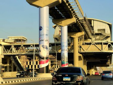 Kahire, Mısır, 28 Ekim 2025: hızlı elektrik treni ve El Ferdan Demiryolu Köprüsü reklamları Kahire 'nin yeni raylı hattının, yeni Mısır altyapı projelerinin sütunlarında