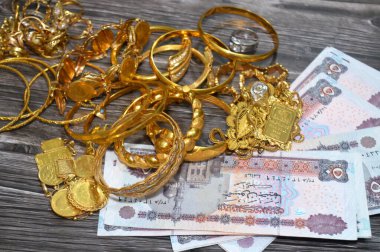 Kahire, Mısır, 29 Ekim 2025: Mısır EGP Pounds ve Altın Mücevher, kişisel süs yüzükleri, kolyeler, bilezikler, altın sikkeler ve Suisse ince altın külçeleri için takılan dekoratif eşyalar