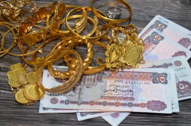Kahire, Mısır, 29 Ekim 2025: Mısır EGP Pounds ve Altın Mücevher, kişisel süs yüzükleri, kolyeler, bilezikler, altın sikkeler ve Suisse ince altın külçeleri için takılan dekoratif eşyalar