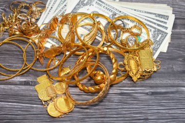 Kahire, Mısır, 29 Ekim 2025: ABD Doları ve Altın Mücevherler, kişisel süs yüzükleri, kolyeler, bilezikler, altın sikkeler ve Suisse ince altın külçeleri için takılan dekoratif eşyalar