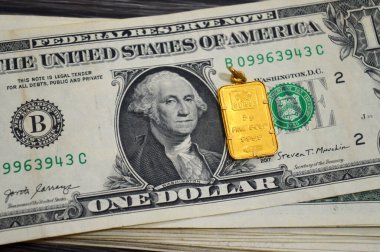 Kahire, Mısır, 29 Ekim 2025: Amerikan doları nakit para banknotları ve PAMP Suisse altın kolyesi, 24K Altın Çubuk 5 gram, saf altın 999.9 gram, yatırım veya tasarruflar için, İsviçre altın rafinerileri