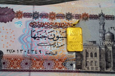 Kahire, Mısır, 29 Ekim 2025: Mısır 'ın EGP' si nakit para banknotları ve PAMP Suisse altın kolyesi, 24K Gold Bar 5 gram, saf altın 999.9 gram, yatırım veya tasarruflar için, altın İsviçre rafinerileri