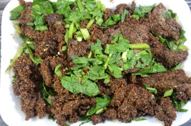 Arap usulü kızarmış sığır ciğeri dilimleri, buğday kebabıyla kaplanmış sığır ciğeri (Kebda Bel Rada), yani kızarmış kepek ciğeri, maydanozla servis edilen, demir ve minerallerle besleyici bir yemek.