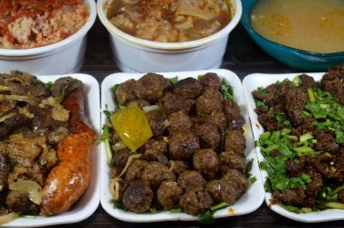 Beyaz pirinçli Mısırlı Fatah, çorbada kemiksiz inek ayağı, paça güveci, iç organların karışık et ve sakatat Meshakel tabağı ve kızarmış sığır ciğeri dilimleri.