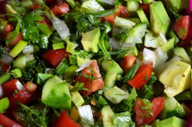 Yeşil salata, taze domates, salatalık, yeşil soğan, avokado, dereotu, maydanoz, marul ve pırasa, taze sebzelerden oluşan sağlıklı yeşil salata.