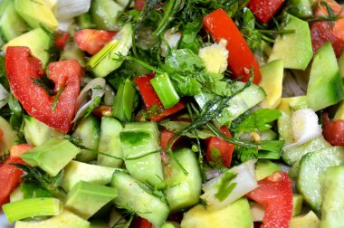Yeşil salata, taze domates, salatalık, yeşil soğan, avokado, dereotu, maydanoz, marul, yeşil biber ve pırasa dilimleri, taze sebzelerden oluşan sağlıklı yeşil salata.