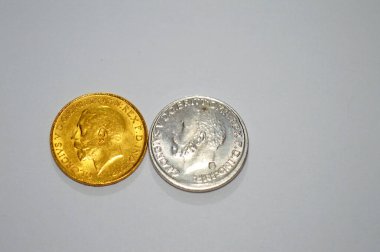 Altın ve gümüşün yan taraflarında, 1 pound sterlin, bir külçe altın değerindeki İngiliz sikkesi Kral George yer almakta ve bazen mücevherlere monte edilmektedir.