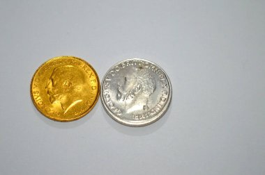 Altın ve gümüşün yan taraflarında, 1 pound sterlin, bir külçe altın değerindeki İngiliz sikkesi Kral George yer almakta ve bazen mücevherlere monte edilmektedir.