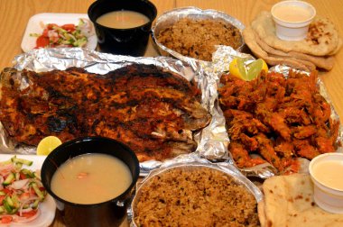 Baharatlı sos, limon, Tilapia, Sinjari Balıkları, Mısır balıklı pilav, pide, Tahini ve yeşil salata ile karıştırılmış çıtır çıtır karides deniz mahsulleri.