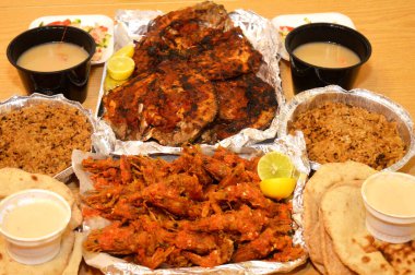 Baharatlı sos, limon, Tilapia, Sinjari Balıkları, Mısır balıklı pilav, pide, Tahini ve yeşil salata ile karıştırılmış çıtır çıtır karides deniz mahsulleri.