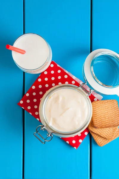 Mavi ahşap bir masa üzerinde ev yapımı yoğurt.
