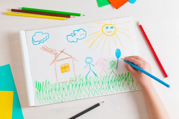 Çocuk evi ve ailesi karakalem çizer.