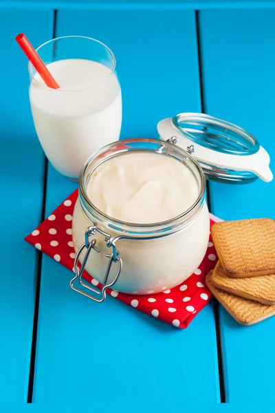 Mavi ahşap bir masa üzerinde ev yapımı yoğurt.