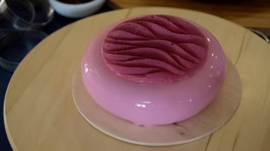 Ahşap tabanlı pembe ayna jöleli modaya uygun kremalı pasta. Modern tatlı..