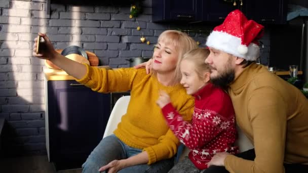 Family taking selfie on smartphone for christmas. Dad, mom and daughter are photographed for new year. — стоковое видео