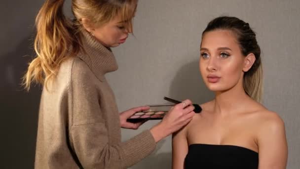 Prozess der Herstellung von Make-up. Visagistin arbeitet mit Pinsel auf Model-Frauengesicht. — Stockvideo