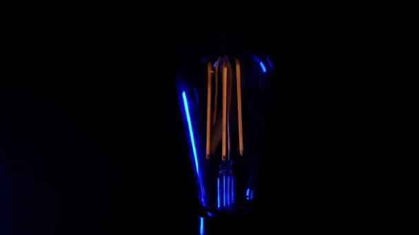 レトロヴィンテージエジソン電球がちらつき、黒を背景にオンになります. — ストック動画