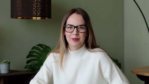 Jovem mulher milenar europeia com óculos falando na câmera em casa escritório. Distância social, educação online. — Vídeo de Stock