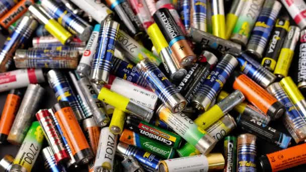 Togliatti, Rússia, 20 de abril de 2021: Muitas baterias AA alcalinas usadas de diferentes fabricantes, coleta, descarte, reciclagem. Poluição da natureza. Fundo da bateria. — Vídeo de Stock