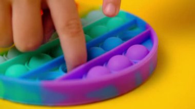 Çocuk popüler masa oyunu oynuyor. Stres önleyici oyuncağı aç..