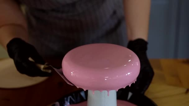 Pink glossy pouring from top of handmade cake. Pastry chef prepares modern french mousse dessert with mirror glaze. — Stock Video