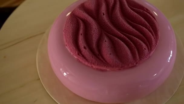 Trendy mousse cake with pink mirror glaze on wooden base. Modern dessert. — Stock Video